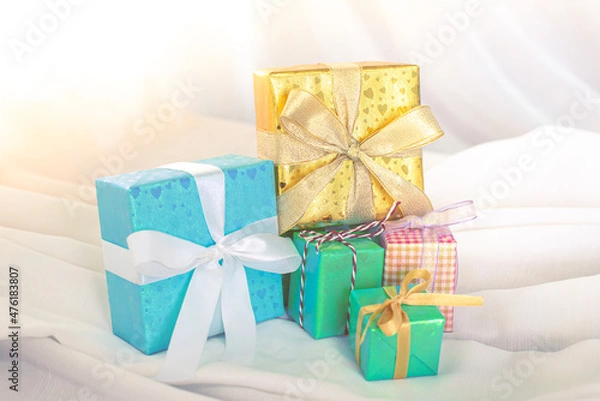 Fototapeta Beautiful Christmas gift boxes. Colored Presents for Birthdays. Boxes with gifts tied with ribbon and bows background. craft paper present box. Christmas tree toys and lights. happy new year 