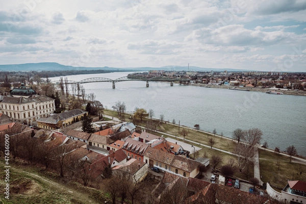 Fototapeta A panoramic view of the Mária Valéria Bridge spanning the Danube River, connecting the cities of Esztergom, Hungary, and Párkány (Štúrovo), Slovakia. The image captures the bridge, the river, and the 