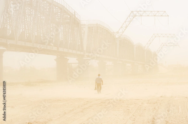Obraz Man walking in a sandstorm