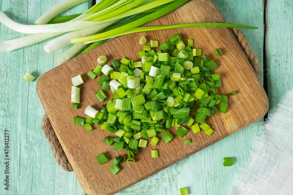 Fototapeta spring onion sliced for salad or seasoning on wooden surface