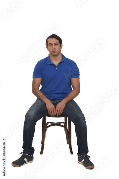 Fototapeta front view of man with ponytail and casual clothing  and tattoos sitting a chair on white background