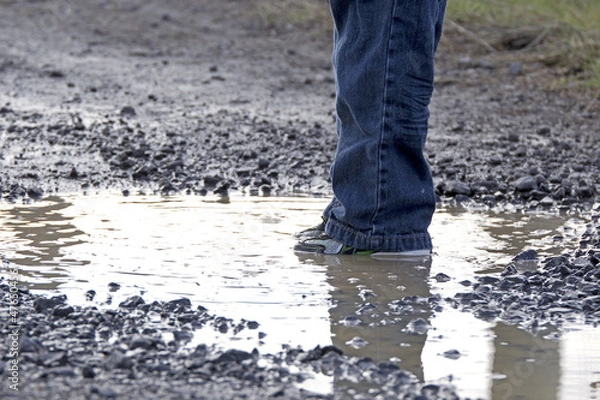 Fototapeta Child Standing Still In Puddle