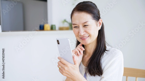 Fototapeta スマホを使うシニア女性