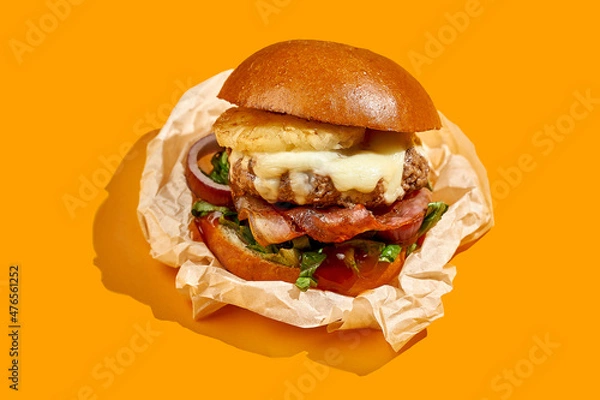 Fototapeta Appetizing burger with pineapple and cheese, bacon on a yellow background