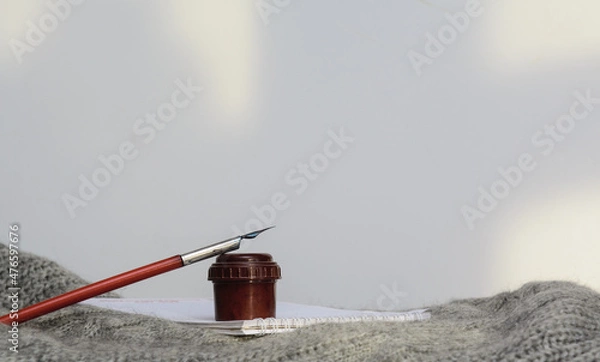 Obraz There is an inkwell with a fountain pen on the notebook. There's a sweater underneath. Copy space