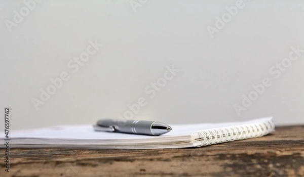 Obraz There is a ballpoint pen on a notebook lying on an old blackboard. Concept business