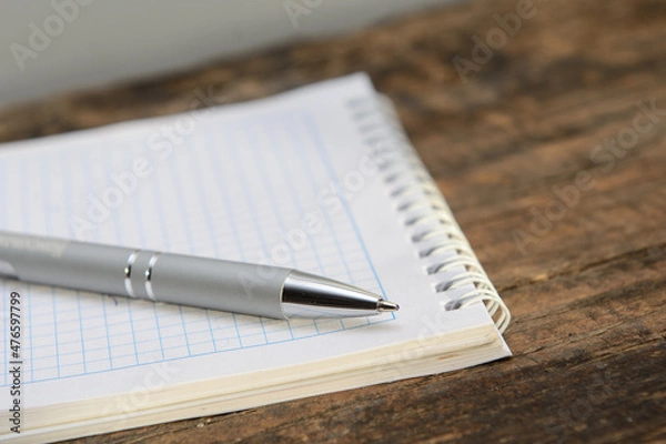 Obraz There is a ballpoint pen on a notebook lying on an old blackboard. Concept business