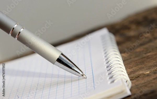 Obraz they write with a ballpoint
pen in a different notebook lying on an old blackboard. Concept - making a plan