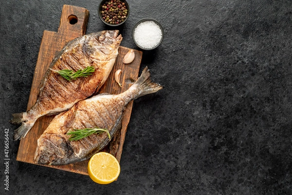 Fototapeta grilled dorado fish on stone background with copy space for your text