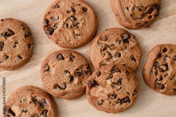 Fototapeta A lot of chocolate chip cookies piled up on a wooden plate.