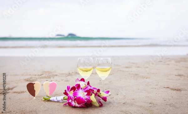 Obraz Романтический символ любви. Цветы и вино на песчаном пляже.