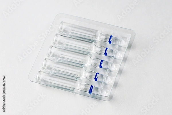 Obraz ampoules with medicine in a transparent tray on a white background