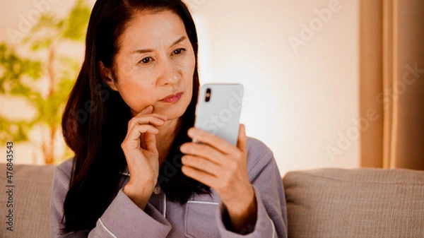 Fototapeta スマートフォンを使うシニア女性