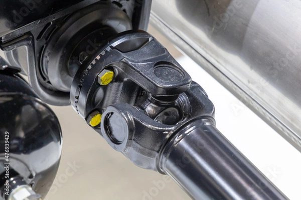 Fototapeta Closeup of a car cardan drive shaft with cardan cross joint and intermediate bearing support. Also known as universal joint, u-joint or cardan joint. Part of the transmission of a truck