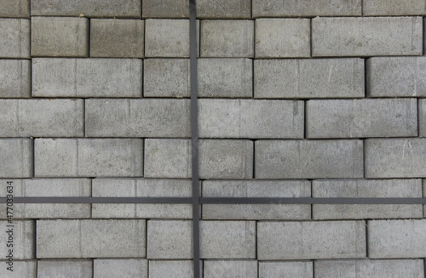 Fototapeta Concrete road tiles for the construction of a parking lot are stacked on top of each other in even rows.