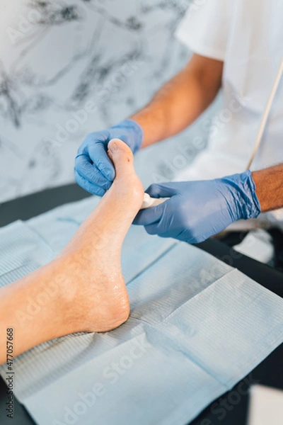 Fototapeta Close-up of a chiropodist doing an ultrasound test to patient's foot.