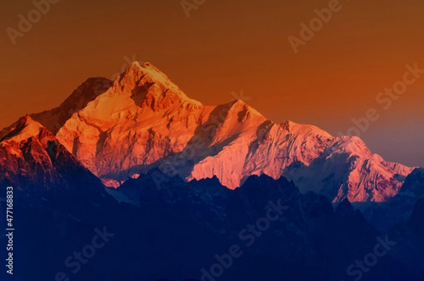 Fototapeta Beautiful first light from sunrise on Mount Kanchenjugha, Himalayan mountain range, Sikkim, India. Orange tint on the mountains at dawn
