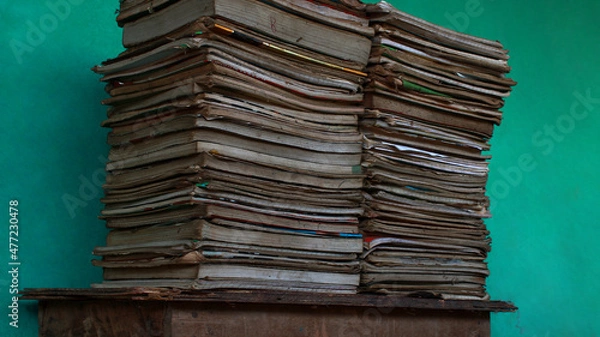 Fototapeta stack of old unused books and copy on table with blue background. education related concept.	