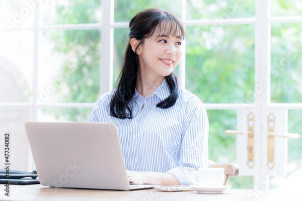 Fototapeta パソコンをしながら遠くを見つめる女性