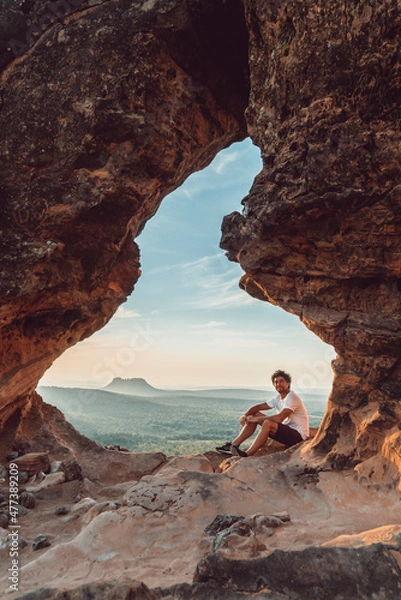Fototapeta Guy seated in Portal da Chapada viewpoint in Chapada das Mesas National Park in Brazil