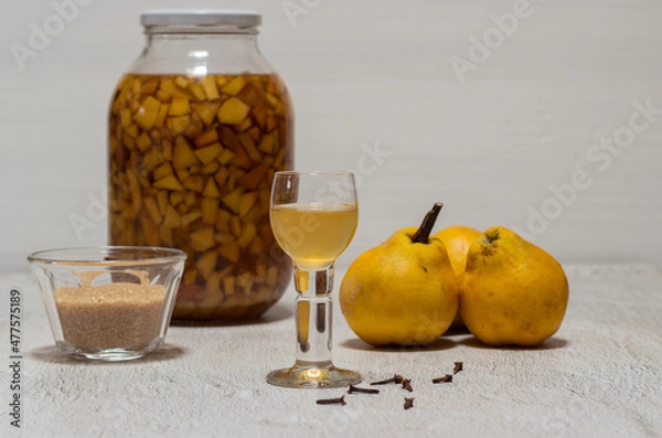 Obraz Homemade quince liqueur. Maceration of quinces in water, cane sugar, cinnamon, cloves and alcohol.