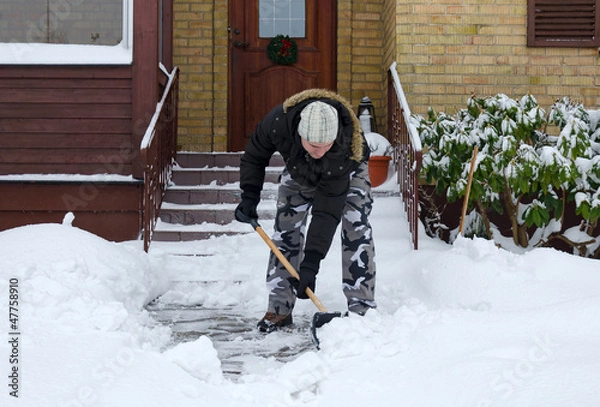 Obraz Man removing snow in front of his house