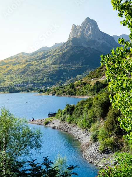 Fototapeta View of the village surrounded by a lake inside the pyrenees