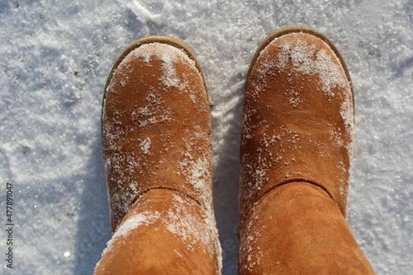 Fototapeta close-up of warm boots, ugg boots in the snow