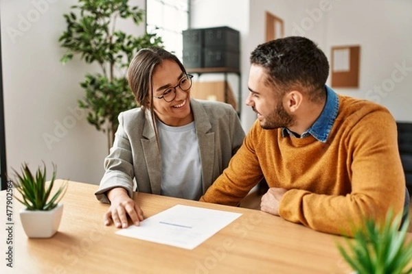 Fototapeta Couple smiling happy reading document at the office.