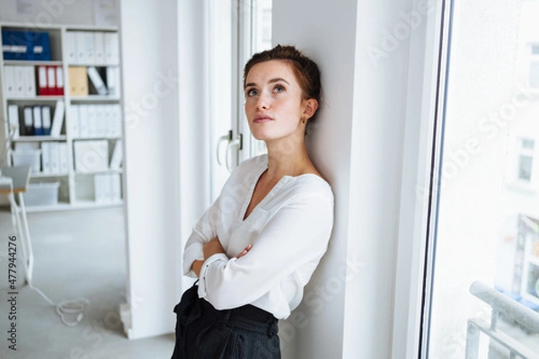 Obraz Serious young businesswoman standing deep in thought