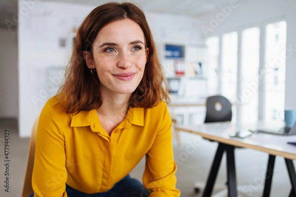 Obraz Young woman taking a break in the office sitting daydreaming
