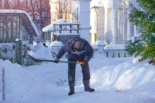 Fototapeta уборка снега лопатой. мужчина убирает снег на улице во дворе