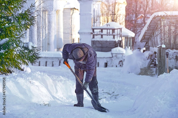 Fototapeta уборка снега лопатой. мужчина убирает снег на улице во дворе