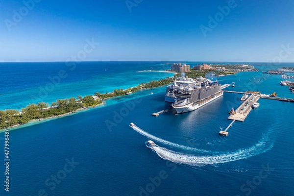 Fototapeta The drone aerial view of cruise ships in the clear blue Caribbean ocean docked in the port of Nassau, Bahamas.
