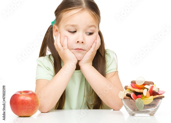 Obraz Little girl choosing between apples and sweets
