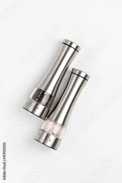 Fototapeta Two electric spice mills for salt and pepper. Metal. On a white table