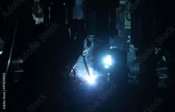 Fototapeta welding robot in the automotive parts industry, The movement of the robot welding in  auto parts factory.