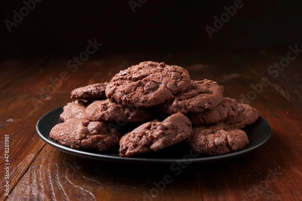 Fototapeta Black plate with homemade triple chocolate chip cookies