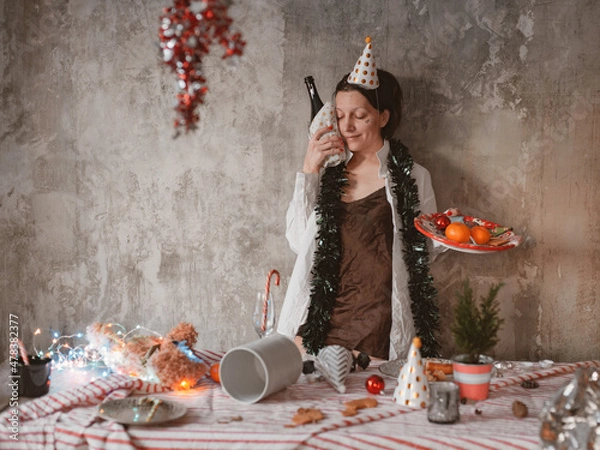 Fototapeta woman has a hangover after a holiday in the morning with a bottle of alcoholic champagne