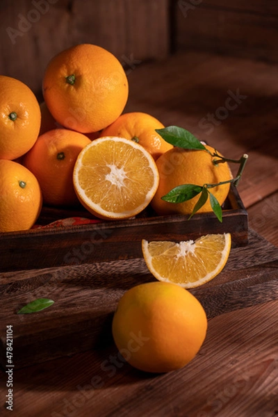 Obraz Under the dim light, the oranges on the plate are on the wooden table, like oil paintings