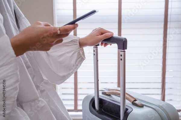 Obraz ビジネス素材　空港の待ち時間でスマホを打つ女性