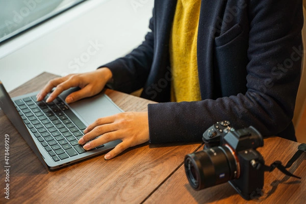 Obraz ビジネス用　女性カメラマンがパソコン作業している素材