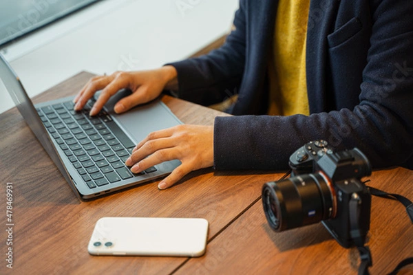 Obraz ビジネス用　女性カメラマンがパソコン作業している素材