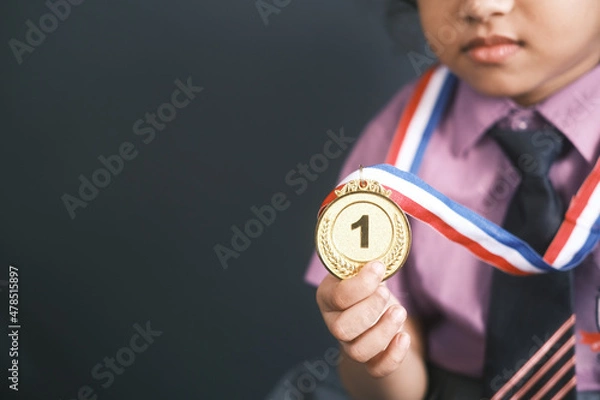 Fototapeta child girl First Place Throphy against gray background 