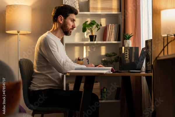 Fototapeta Stressed male entrepreneur having problems at work. Serious caucasian man sitting at desk
