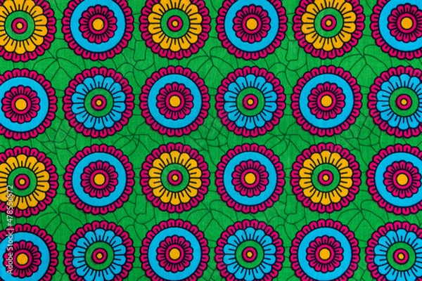 Obraz Colorful african printed textile close-up. Ethnic geometric pattern, fabric from Tanzania with abstract floral motif and vibrant colors.