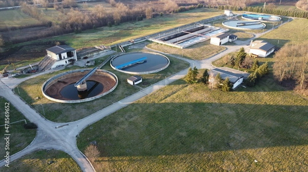 Fototapeta Aerial view of a wastewater treatment plant. During purification, chemicals and microorganisms are removed from the water and the water is returned to river and sea watercourses.