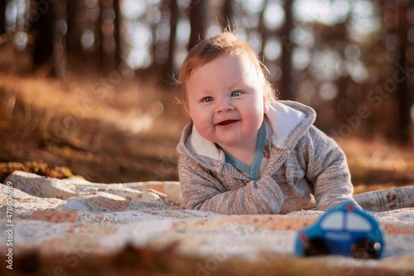 Obraz An eight-month-old boy lying on a blanket in the forest.