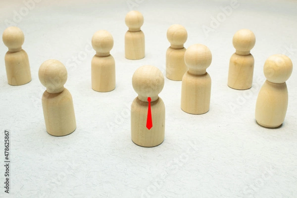 Fototapeta Small group of separated people seen from above represented anonymous with wooden figures on white background