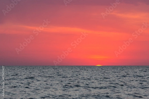 Fototapeta The sun peeked over the horizon at dawn. Dawn over the sea.